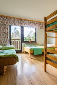a bedroom with two bunk beds and a window at Willa OdNova in Tylicz