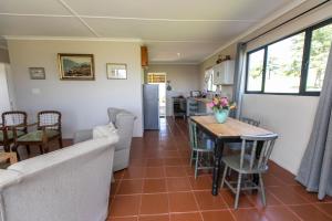 a kitchen and dining room with a table and chairs at Granny Smith Cottage in Himeville