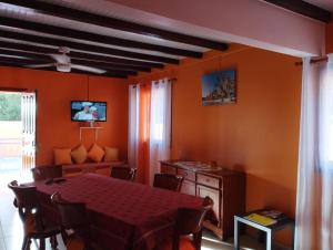 a dining room with a table and a couch at Le Papillon Bleu in Bouillante