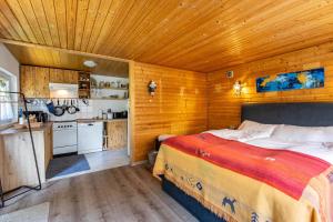 a bedroom with a large bed and a kitchen at Garden House in Kiel