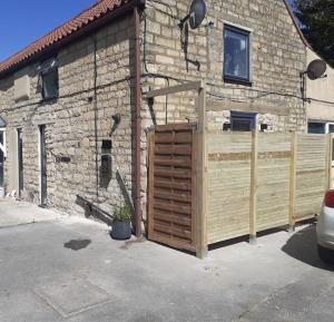 une grange avec une porte en bois devant un bâtiment dans l'établissement Justaura Retreat, à Branston