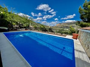 une piscine bleue avec une montagne en arrière-plan dans l'établissement Finca La María, à Jaén