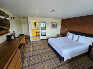 a hotel room with a large bed and a kitchen at The Hotel Laurel at Seneca in Watkins Glen