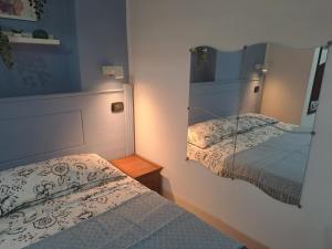 シッラにあるLa bottegucciaのベッドルーム1室(ツインベッド2台、鏡付)