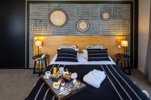 a bedroom with a bed with a tray of food on it at Garrigae Manoir de Beauvoir Poitiers Sud - Hotel & Spa in Mignaloux-Beauvoir