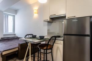 a kitchen with a stainless steel refrigerator and a table at Studio Dendrarium park in Chişinău