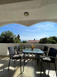 patio con mesa y sillas en el balcón en Apartments Amelie, en Zadar