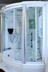 a white shower with glass doors in a room at Airport Royal Guest House in Kempton Park