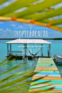 a table on a dock with a body of water at Tropic Bacalar in Bacalar