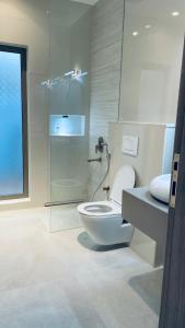 a bathroom with a toilet and a glass shower at شاليهات بلاسيو 