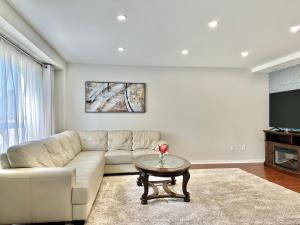 uma sala de estar com um sofá e uma mesa em Lavish 4BR House Near Simcoe Lake & FH Resort em Innisfil