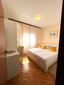 1 dormitorio con cama, escritorio y ventana en Apartments Amelie, en Zadar