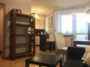 uma sala de estar com uma estante de livros e uma mesa em Apartamenty Nad Jeziorkiem em Varsóvia