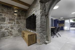 sala de estar con pared de piedra y TV en Luxury 5 stars villa Berisha en Krk