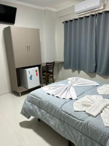 ein Schlafzimmer mit einem Bett und einem TV. in der Unterkunft Hotel Beirut in Aparecida