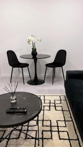 sala de estar con sofá, mesa y sillas en Neptun guest house en Queluz