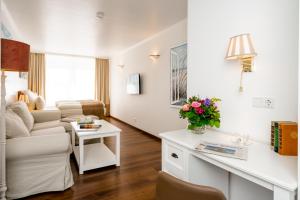 ein Wohnzimmer mit einem Sofa und einem Tisch in der Unterkunft Hotel von Stephan in Westerland