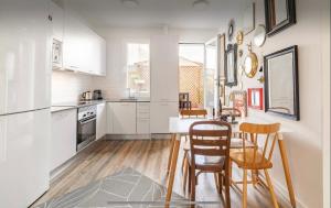 a kitchen with white cabinets and a table and chairs at Habitación Simple en PISO COMPARTIDO C in Madrid