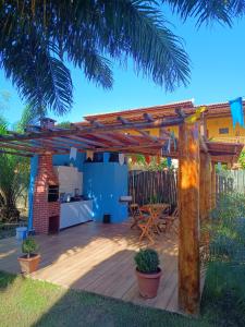 a patio with a wooden pergola and a table at Vila Itacimirim in Itacimirim
