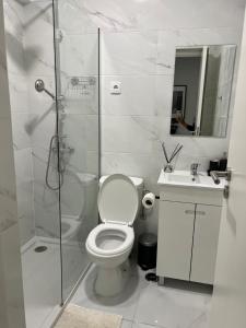 y baño con ducha, aseo y lavamanos. en Neptun guest house en Queluz