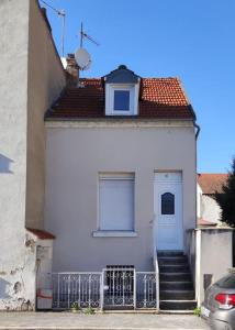 une maison blanche avec des escaliers menant à une porte dans l'établissement Maison de ville, SPA Balnéo, 2 suites parentales, à Vichy