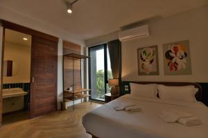 um quarto com uma cama grande e uma janela grande em KWANS Ayutthaya em Phra Nakhon Si Ayutthaya