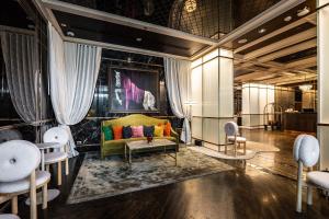 a living room with a green couch and chairs at MUU Bangkok, Small Luxury Hotels of the World in Bangkok +113 photos