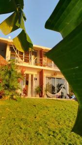 une maison avec une pelouse verte devant elle dans l'établissement Tropic Bacalar, à Bacalar