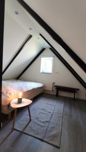 Zimmer im Dachgeschoss mit einem Bett und einem Tisch in der Unterkunft Leef Zuiden in Simpelveld