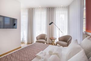 波多的住宿－Alliança Suites 1909 - Porto，卧室配有白色的床和2把椅子