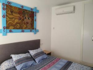 a bedroom with a bed with a painting on the wall at Apartamento a estrenar en Planta Primera C con piscina in Barbate +6 photos