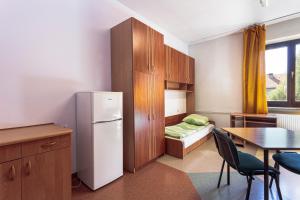 a kitchen with a refrigerator and a table and a bed at Dizzy Daisy Hostel in Wrocław