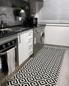 uma cozinha com um lavatório e uma máquina de lavar roupa em Neptun guest house em Queluz