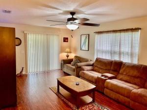 - un salon avec un canapé et un ventilateur de plafond dans l'établissement Cozy Modest Home near Universal Studios/VolcanoBay, à Orlando