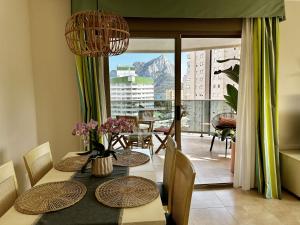een eetkamer met een tafel en uitzicht op een berg bij Esmeralda Suites in Calpe