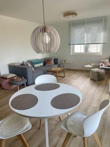 sala de estar con mesa blanca y sillas en Fewo Elena 150 m bis zum Strand, en Altefähr