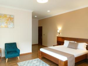 a bedroom with a bed and a blue chair at SOA LIA HOTEL in Miandrivazo +48 photos