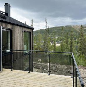 a house with a glass railing on a deck at Lovely winter cottage in Vemdalen, close to skiing in Vemdalen