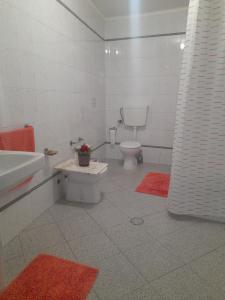 a white bathroom with a toilet and a sink at Rose Rooms in Faro