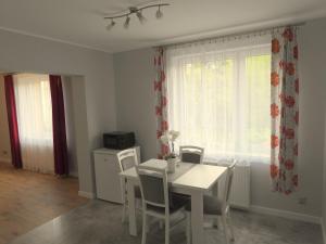 a dining room with a white table and chairs at Apartament Magnolia in Muszyna
