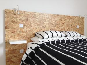 a bedroom with a bed with black and white pillows at Quinta das Rosas Villas in Ribeira Grande