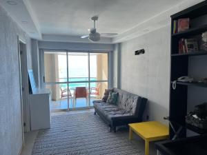 sala de estar con sofá y vistas al océano en ApartHotel Villa Del Sol, en Río de Janeiro