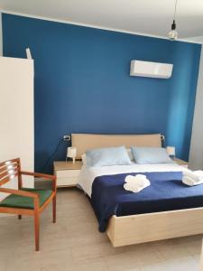 una camera blu con un letto e una sedia di B&B Crispino a Belvedere Marittimo