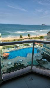 balcón con vistas a la playa y a la piscina en ApartHotel Villa Del Sol, en Río de Janeiro
