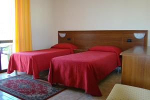 a room with two beds with red sheets at Hotel Ristorante111 in Villapiana +27 photos