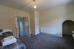 a room with a bed and a hallway with a door at Flat 2 @ 28 Chilkwell Street in Glastonbury