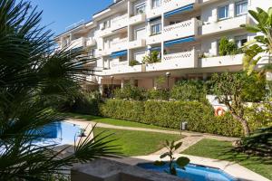 un immeuble d'appartements avec piscine et palmiers dans l'établissement San Pedro del Mar, à Marbella