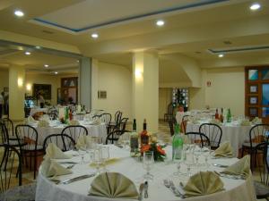 a dining room with tables and chairs with white table linen at Hotel Ristorante111 in Villapiana