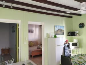 cocina y sala de estar con nevera blanca en Le Papillon Bleu, en Bouillante