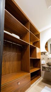 a large wooden closet with wooden shelves in a bathroom at Marron studios 1 new in Cairo